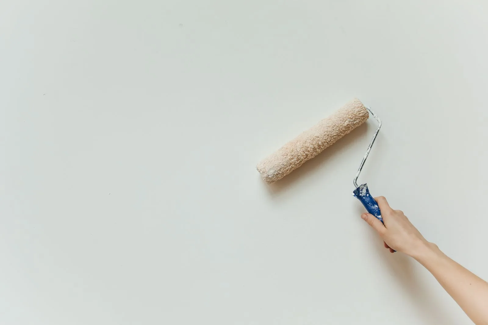 Painter rolling fresh paint on an interior wall